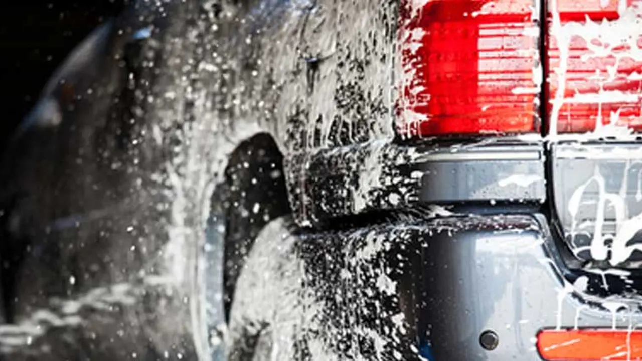 blue bowl of black bean beef tortilla soup on a board with cilantro and shredded cheese in background