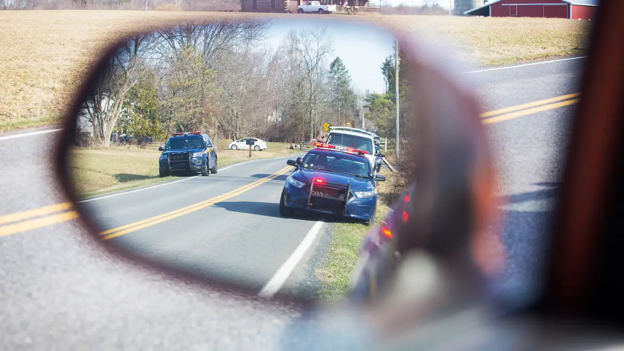 blue bowl of black bean beef tortilla soup on a board with cilantro and shredded cheese in background